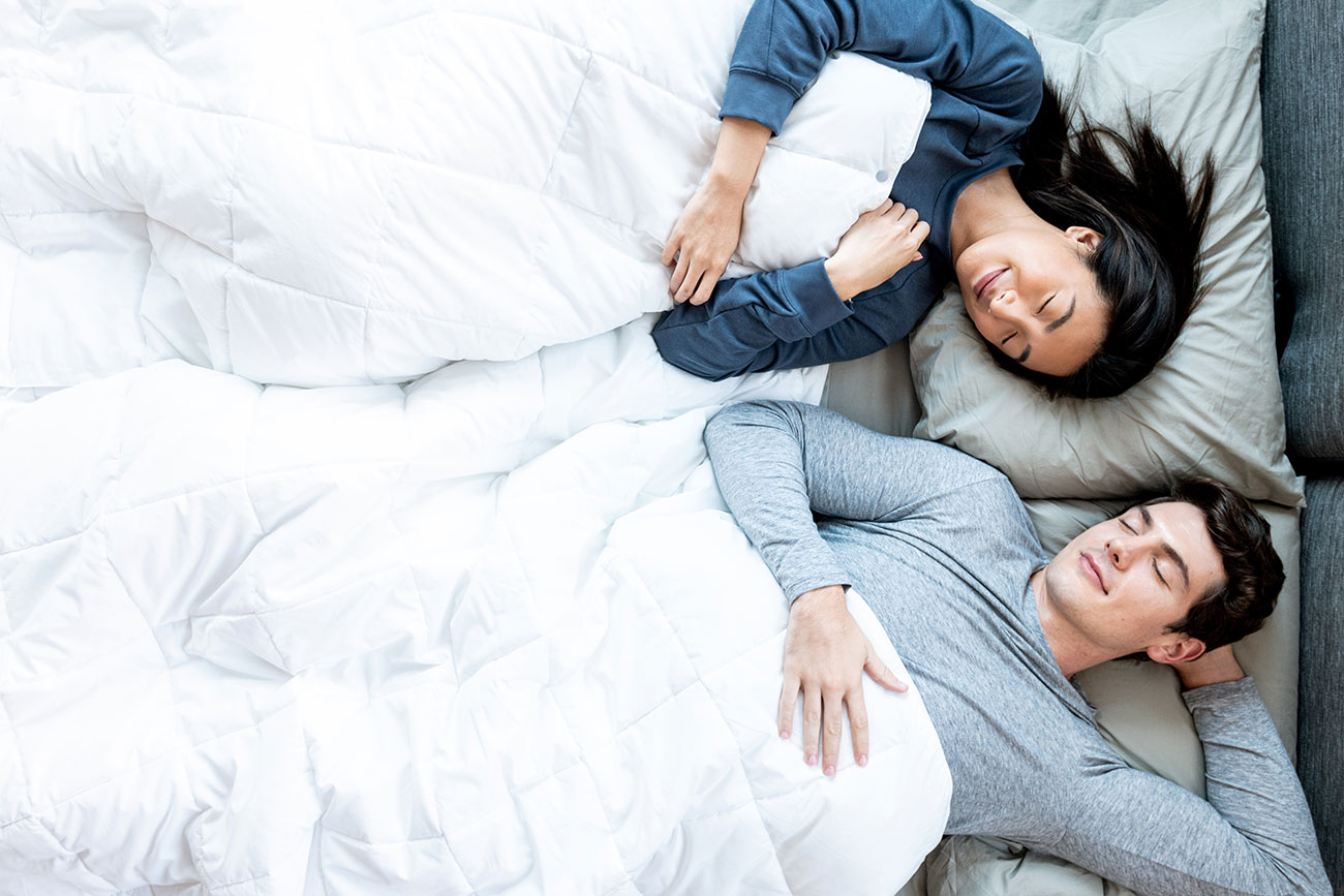 couple sleeping in bed with apollo duvet