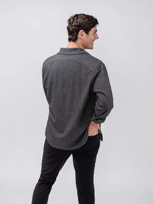 Model wearing Black Pace Tapered Chino and Charcoal Tweed Fusion Overshirt and Pale Grey Heather Composite Merino Tee facing away with hand in back pocket