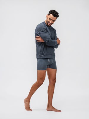 model wearing deep indigo composite merino boxer brief and navy fusion terry sweatshirt facing off to the side and hugging self