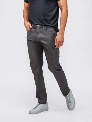 model wearing dark grey chroma denim and black composite merino zip polo facing forward with hand in pocket