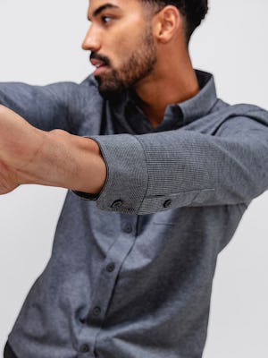 model wearing Grey Tonal Stripe Men's Hybrid Button-Down and Grey Heather Velocity Flannel Pant facing forward doing an arm stretch