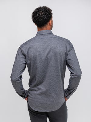 model wearing Grey Tonal Stripe Men's Hybrid Button-Down and Grey Heather Velocity Flannel Pant facing away with hands in pockets