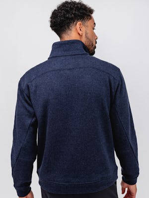 model wearing men's indigo heather hybrid 1/4 zip pullover facing away