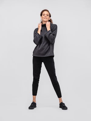 model wearing women's black tweed hybrid mock neck sweater and black kinetic pull on pant facing forward with hands on collar