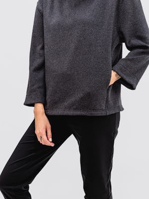 model wearing women's black tweed hybrid mock neck sweater and black kinetic pull on pant facing forward with hand in pocket