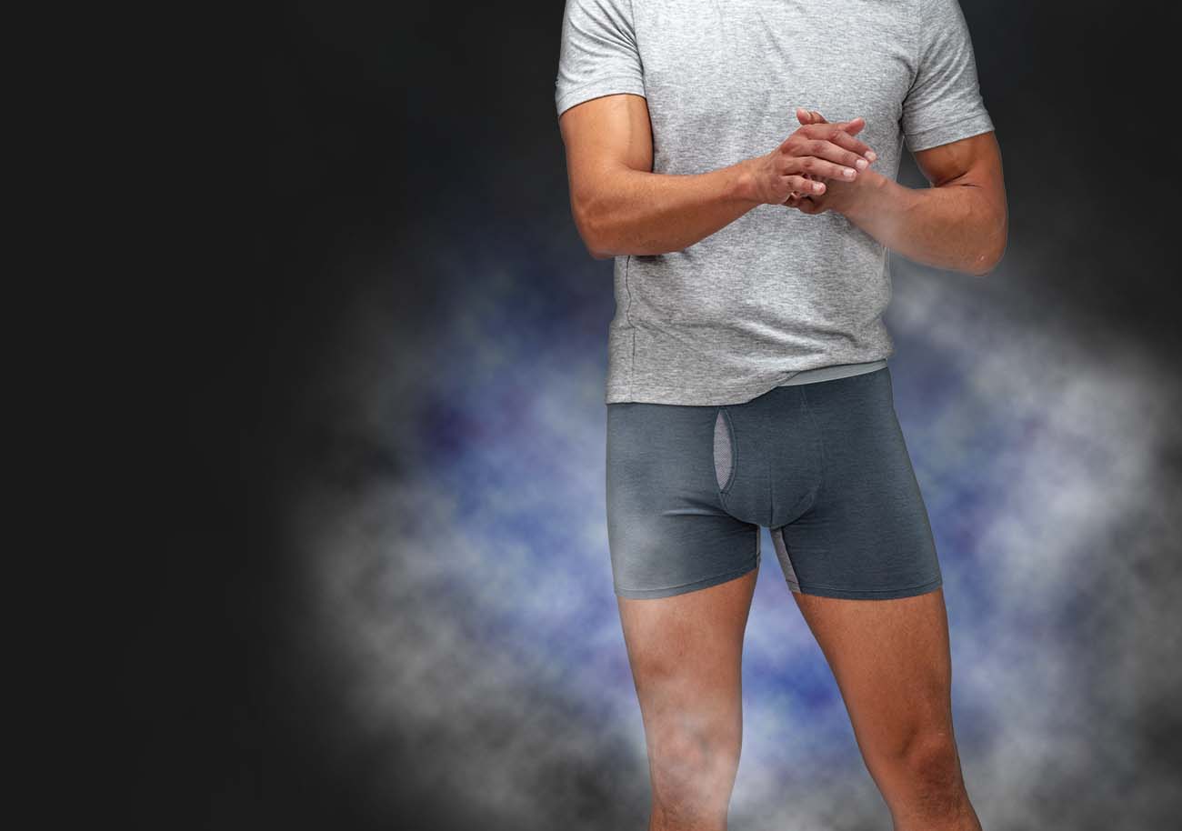 model wearing composite merino boxer briefs in front of a cloud of vapor
