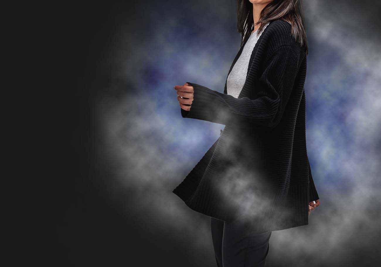 model wearing composite merino cardigan in front of a cloud of vapor