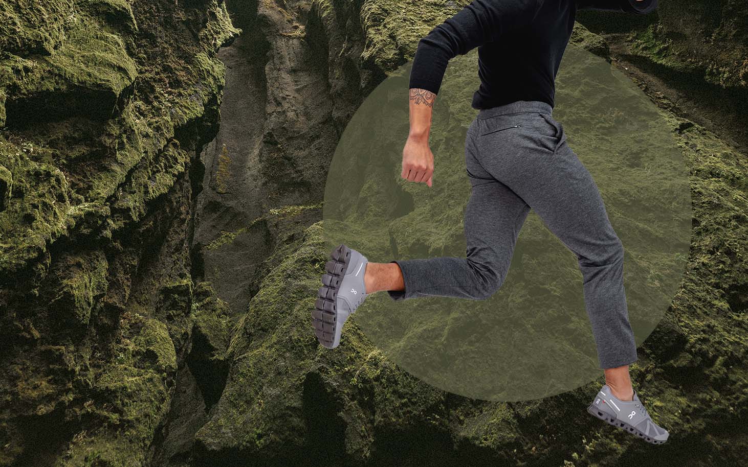 model wearing men's fusion pant leaping in front of a mossy background