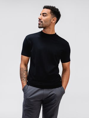 model wearing black atlas high crew tee and charcoal kinetic jogger with hands in pockets