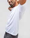 model wearing white atlas high crew tee facing forward with arms up to show ventilation