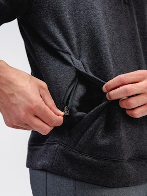Close up of Men's Black Tweed Hybrid Fleece 1/4 Zip Pullover on model with hand zipping pocket