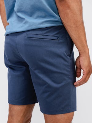 model wearing men's slate blue kinetic pull on short and stone blue composite merino tee zoomed shot of back