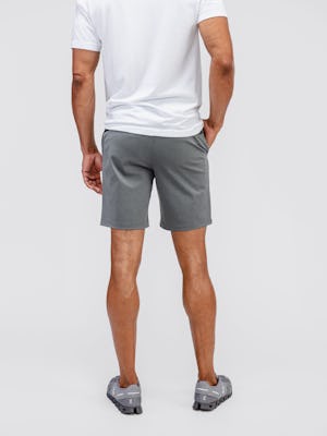 model wearing men's slate grey kinetic pull on short and white atlas v neck tee facing away with hand in pocket