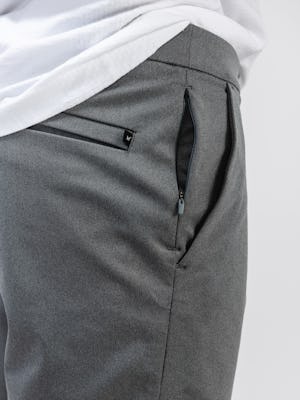 model wearing men's slate grey kinetic pull on short and white atlas v neck tee zoomed shot of hidden zip pocket