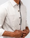 model wearing mens pace poplin overshirt stone side angle detailed shot holding buttons