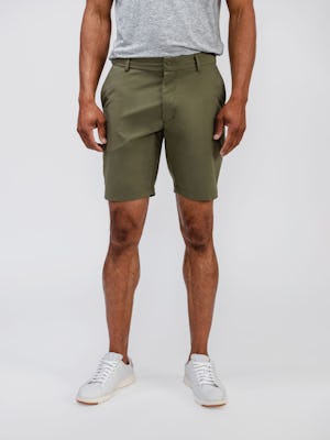 model wearing mens olive pace poplin shorts and mens composite merino tee pale grey heather standing below waist short 