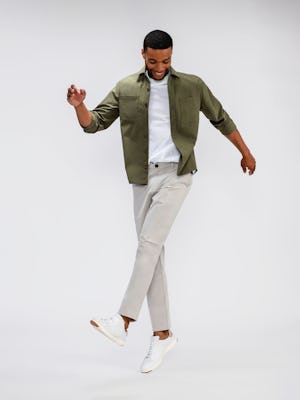 mens pace poplin overshirt olive and mens pace tapered chino light khaki on model standing one leg up hopping