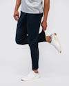 model wearing mens kinetic jogger navy and mens apollo polo pulling and stretching end of jogger 