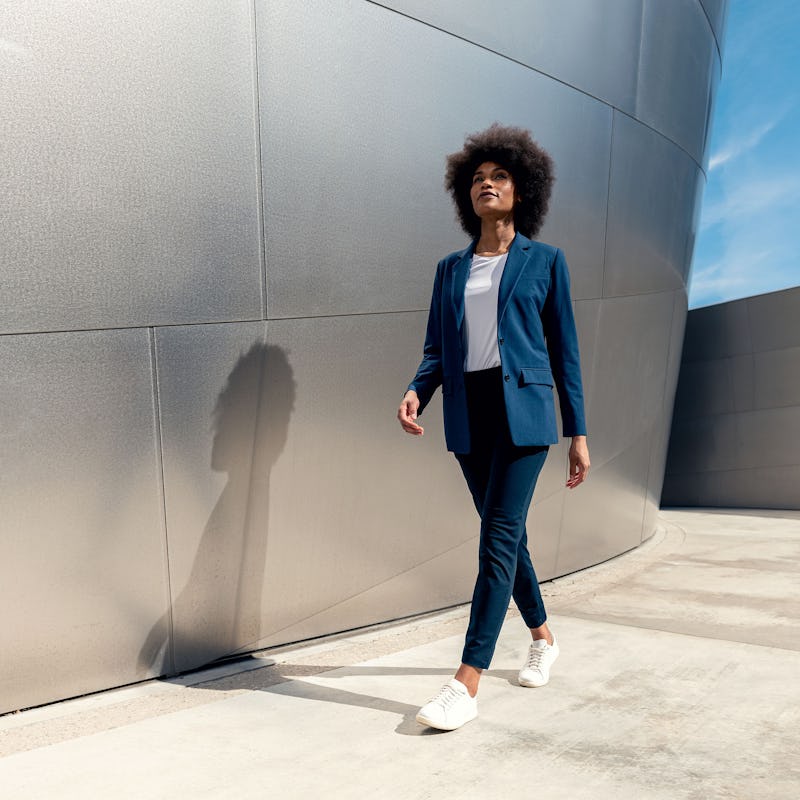 model wearing womens velocity oversized blazer indigo heather and womens luxe tee white and womens kinetic pull on pant navy walking looking up