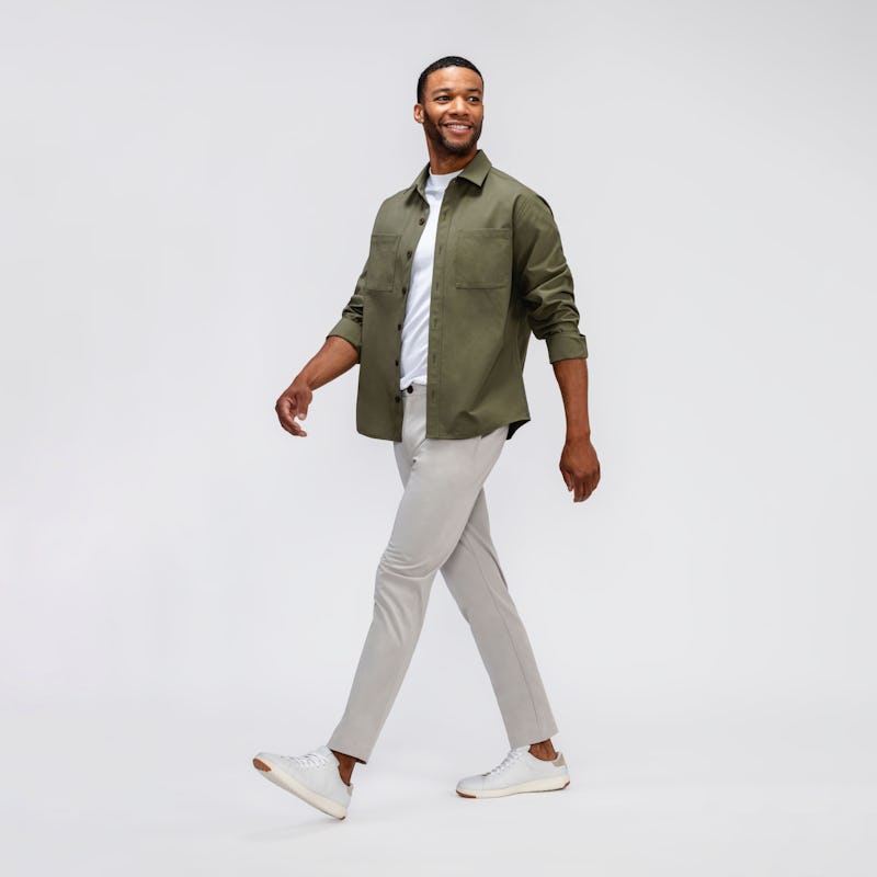 model wearing mens pace poplin overshirt olive and mens atlas cre neck tee white and mens pace tapered chino light khaki walking sideways looking in front
