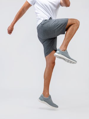 model wearing men fusion terry short classic grey heather and men apollo polo white and rockport shoes bottom half one leg up stretch