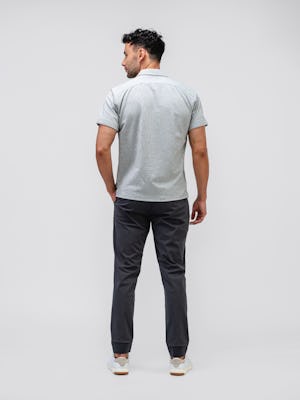 model wearing Men's Grey Tonal Stripe Hybrid Seersucker Short Sleeve Shirt and slate grey kinetic jogger facing away with hand in pocket