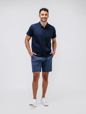 model wearing Men's Navy Hybrid Seersucker Short Sleeve Shirt and slate blue kinetic pull-on short facing forward with hands in pockets