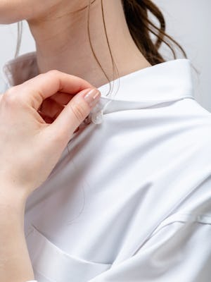 model wearing white aero zero oversized shirt zoomed in on hidden collar button