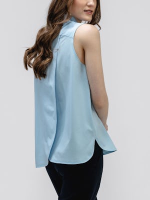 model wearing women's chambray blue juno mock neck tank facing away with hands clasped in front