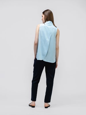 model wearing women's chambray blue juno mock neck tank facing away with hand in pocket