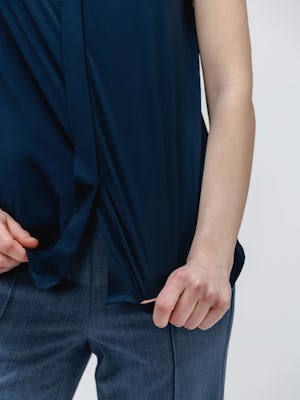 Close up of Navy Juno Mock Neck Tank on model stretching fabric