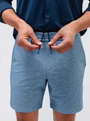 model wearing men's lunar blue fusion terry short and navy apollo raglan sport shirt close up of hidden drawstring