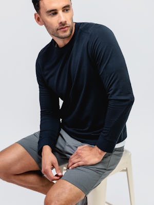 model wearing men's black heather fusion terry sweatshirt and slate grey kinetic pull on short sitting on a stool