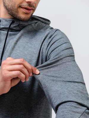 close up of male model wearing classic grey heather fusion terry for all hoodie stretching sleeve fabric