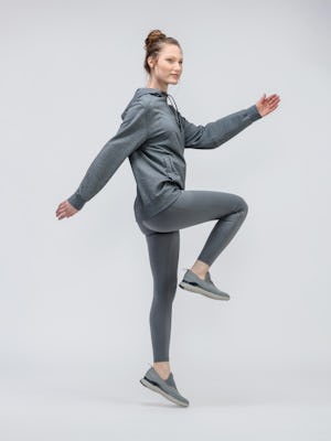 model wearing women joule active legging charcoal and terry for all hoodie classic grey heather jumping one leg in air