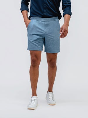 model wearing men's lunar blue fusion terry short and navy apollo raglan sport shirt facing forward with hand in pocket