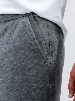 model wearing men's classic grey heather fusion terry short and white apollo polo close up of zip pockets