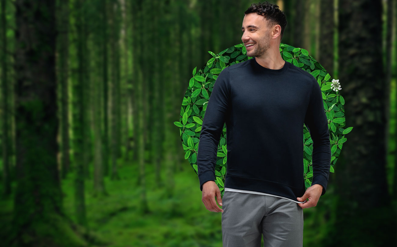 model wearing men's black heather fusion terry sweatshirt in a forest