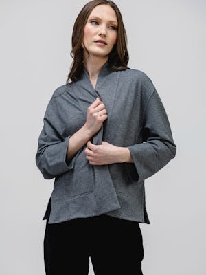 model wearing women's classic grey heather fusion terry cardigan and black swift wide leg pull on pant facing forward clasping cardigan closed
