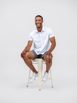 men's on model white apollo short sleeve sport shirt and kinetic shorts sitting on stool