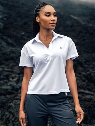 model wearing white limited edition women's apollo polo and kinetic pull-on pant outdoors