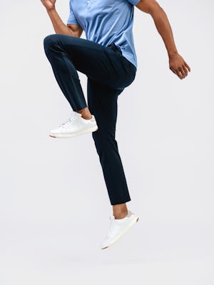 model wearing mens kinetic jogger navy jumping one leg bend in air other leg straight