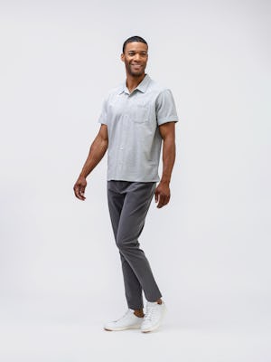 model wearing mens kinetic jogger slate grey and hybrid seersucker short sleeve shirt grey tonal stripe full body walking sideways arms on side