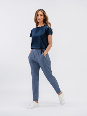 model wearing women's indigo heather fusion terry joggerfull body front shot both hands in pocket one leg on tippy toe