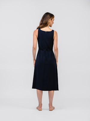 model wearing women's navy swift sheath dress facing backwards full