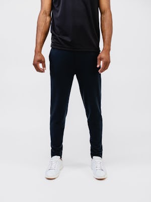 model wearing mens fusion terry jogger black and mens apollo polo black below neck shot arms on side front