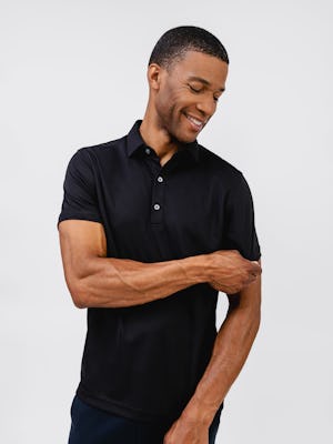model wearing mens apollo polo black and mens fusion terry jogger black waist up front pulling on sleeve