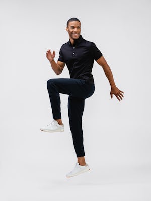 model wearing mens fusion terry jogger black and mens apollo polo black full body jumping one leg in air