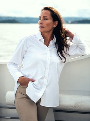 model wearing womens aero zero oversized shirt white lifestyle looking sideways on boat sea background