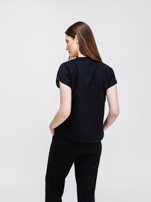 model wearing womens fusion double knit reversible tee black charcoal on model back shot both hands in pocket